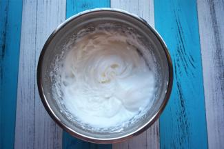 将柠檬汁滴入蛋白中，分三次加入细砂糖，打发至硬性发泡。