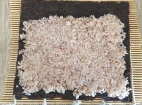 把红梗米饭均匀铺在上面，可用小勺适当压平，增加粘合