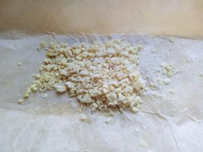 熟花生放在菜板上，并垫上油纸，再盖上一张油纸，用擀面杖来回碾压，直至碾为止。(也可以用刀拍碎。)