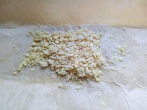 熟花生放在菜板上，并垫上油纸，再盖上一张油纸，用擀面杖来回碾压，直至碾为止。(也可以用刀拍碎。)