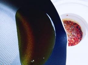 将热油倒入辣椒粉器具中。