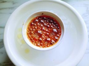 将装油辣子的器具，放在热水的大口器具中，(这样防止器具经高温后爆裂，还有就是溢出的油很容易清理。)