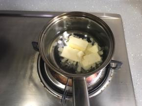 制作泡芙。将黄油、盐和清水倒入奶锅，小火加热。