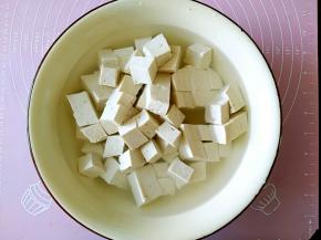 把豆腐切成小正方形，用开水加适量的盐浸泡10分钟