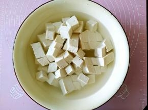 把豆腐切成小正方形，用开水加适量的盐浸泡10分钟