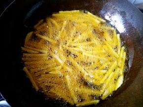 炒锅中入足够多的植物油，在油温达到六七成热的时候把土豆条放进去炸，要用勺子多加搅拌，使之受热均匀。在油温降低的时候用漏勺捞出土豆条，等油温再次升高的时候放入锅中复炸，这样的步骤可以重复两遍至三遍。