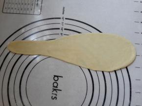 把面团排气擀成水滴形，从大往小卷起。