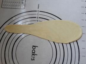 把面团排气擀成水滴形，从大往小卷起。