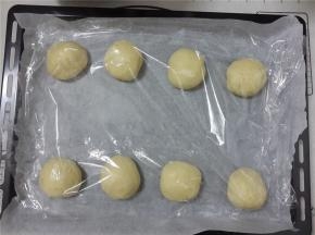 然后排气分成8个剂子。整理成圆形。一个圆形是50g。盖上保鲜膜醒发15分钟。