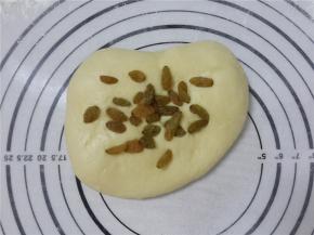 再次将面团压扁，放入剩下的葡萄干。