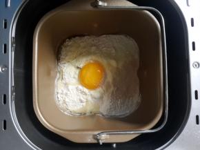 晒入高筋面粉和低筋面粉奶粉。加入一个鸡蛋。加入酵母粉。