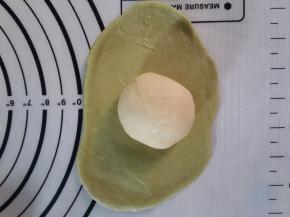 把抹茶的擀成圆形，包住原味的。收口要向下。