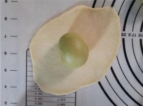 同样如此。把原味的面团也擀成圆形。包住抹茶面团。收口向下。