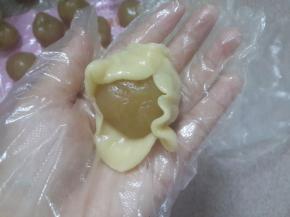 面团捏成薄片轻轻的包住莲蓉收口。