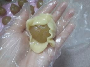 面团捏成薄片轻轻的包住莲蓉收口。