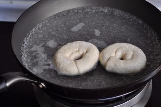 醒发的差不多时，就要在锅中用1000毫升水加上50克糖煮水，同进，将烤箱打开200预热，不要等水沸腾，冒小泡时，就把贝果向下放入，同时将垫在下面的油纸揭下来。