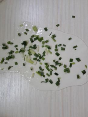 两个均匀的擀平擀薄，然后用刷子刷上油，撒上葱花。