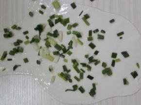 两个均匀的擀平擀薄，然后用刷子刷上油，撒上葱花。