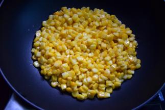 锅中加适量油，比较炒菜稍多一些，烧热后倒入玉米粒，不要立即拨动