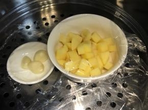 土豆去皮切丁，大蒜去皮，上锅蒸30分钟，蒸熟透