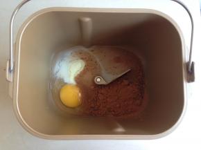 将水、蛋液、糖、盐、奶粉、可可粉依次放入到面包桶里