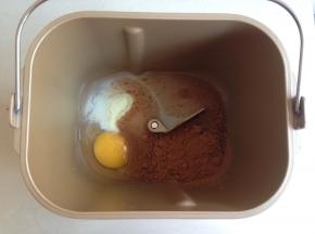 将水、蛋液、糖、盐、奶粉、可可粉依次放入到面包桶里