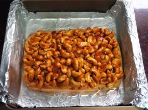 将拌好的腰果铺放在饼干底上，压紧，重新放入烤箱，180度中层烤10分钟。