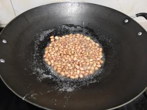白糖很快融化，并且冒泡沸腾。这个时候加入花生米。马上关火。