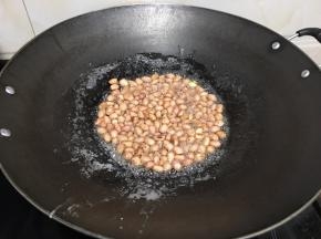 白糖很快融化，并且冒泡沸腾。这个时候加入花生米。马上关火。