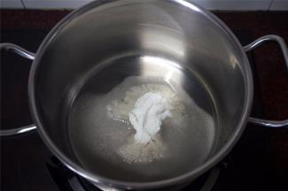 锅里放入打碎了的砂糖和25克清水。