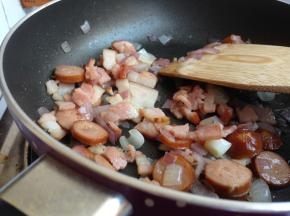 加入切成小块的培根和脆皮肠，翻炒几下，备用