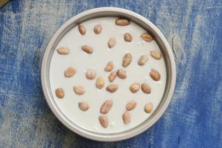 轻轻磕出气泡，然后在表面放上事先浸泡过的花生