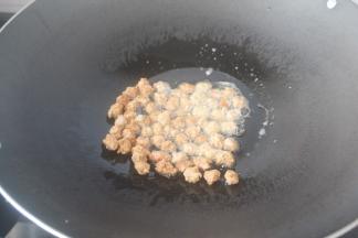 锅里放比平时炒菜多一半的油，中小火2分钟后用筷子或者用手也可以，一粒粒的往锅里夹，记得火要马上改成小火。炸到稍微变色就要拿出来马上控油了。