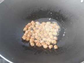 锅里放比平时炒菜多一半的油，中小火2分钟后用筷子或者用手也可以，一粒粒的往锅里夹，记得火要马上改成小火。炸到稍微变色就要拿出来马上控油了。