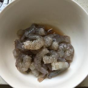 放1克盐、1汤匙料酒和少许胡椒粉，用手抓至虾发粘
