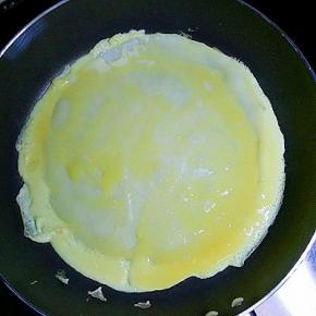 倒入适量打散的鸡蛋液（可直接把鸡蛋打在上面，用勺子摊均匀）