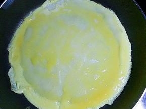 倒入适量打散的鸡蛋液（可直接把鸡蛋打在上面，用勺子摊均匀）