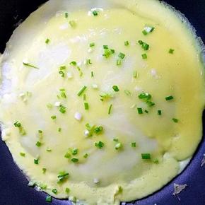 表面撒香葱碎，鸡蛋液凝固后翻面