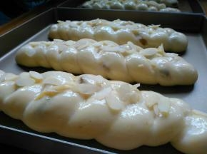 用烤箱的发酵档发酵50分钟左右。发酵好的面包坯涂蛋液，放上杏仁片。