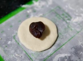 取一个面团擀成圆形，包入适量红豆沙