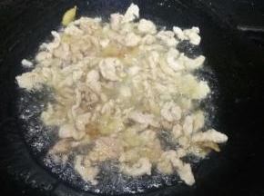 炒至猪肉变色后，倒入切好的大蒜，炒出大蒜的香味