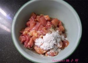 将鸡腿肉切丁后放入料理碗里，加入料酒、白胡椒粉、淀粉、食用油5克抓拌均匀，腌制15分钟；