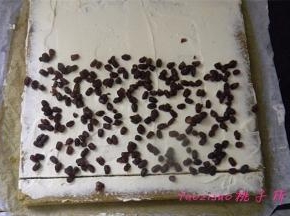 将油纸铺垫在蛋糕的下面，用抹刀将淡奶油抹平，并撒上蜜蜜红豆；