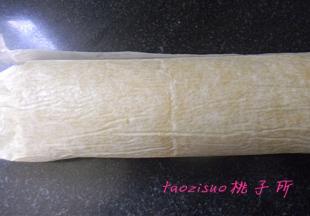 提起铺垫的油纸的一边，慢慢将蛋糕卷起，一直卷到蛋糕的另一侧，卷实后，放入冰箱冷藏室1个小时后可切片食用。