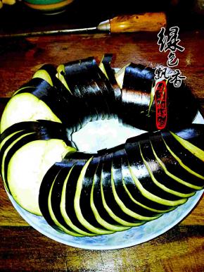 将长茄子洗净，切成片，正反面直刀切，底部不切断，成蓑衣状