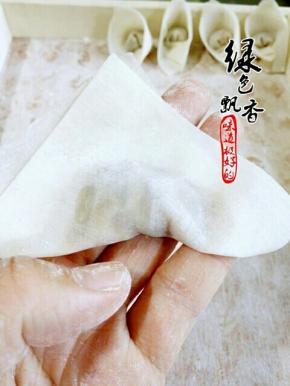 将馄饨皮对折，按压