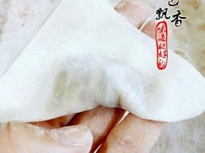 将馄饨皮对折，按压