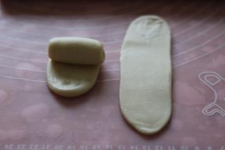 取一个卷再次擀开，擀成长舌型，翻面从上往下卷起。