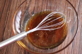 玻璃碗，倒入糖浆，枧水，花生油用手动打蛋器搅匀。