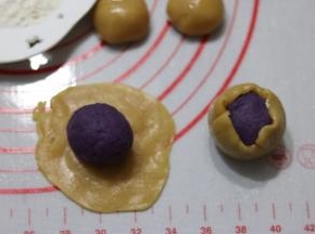 取一个饼皮按扁包入馅料，用虎口慢慢收口，滚圆。